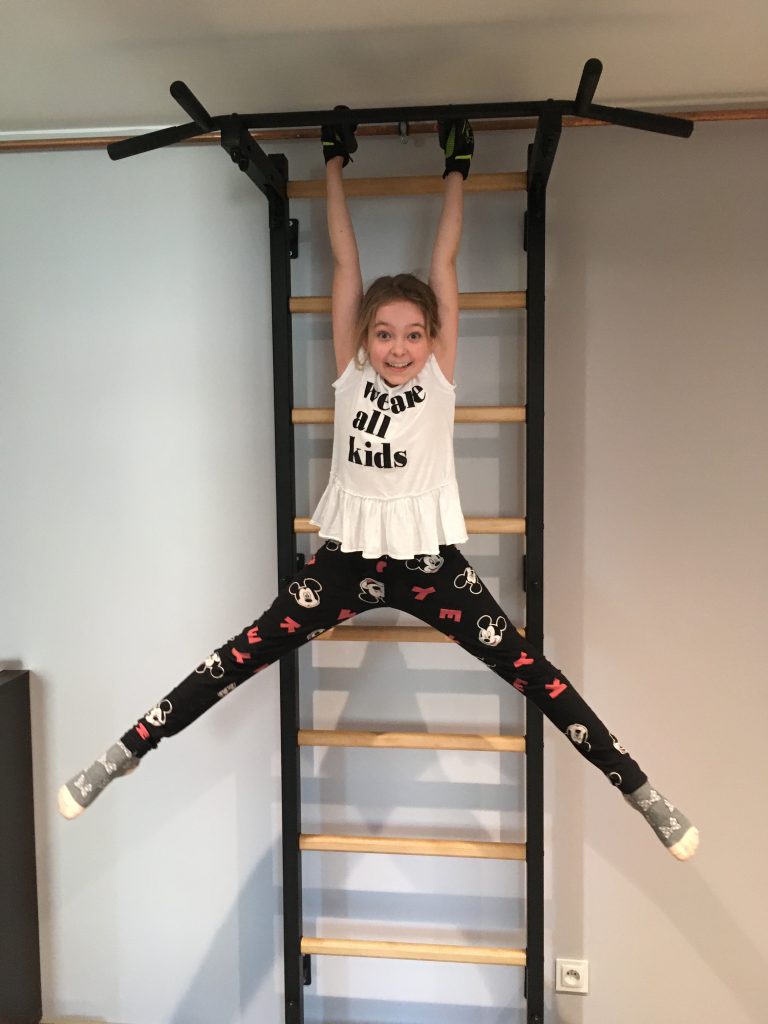 A child at a sports activity on a gymnastics ladder