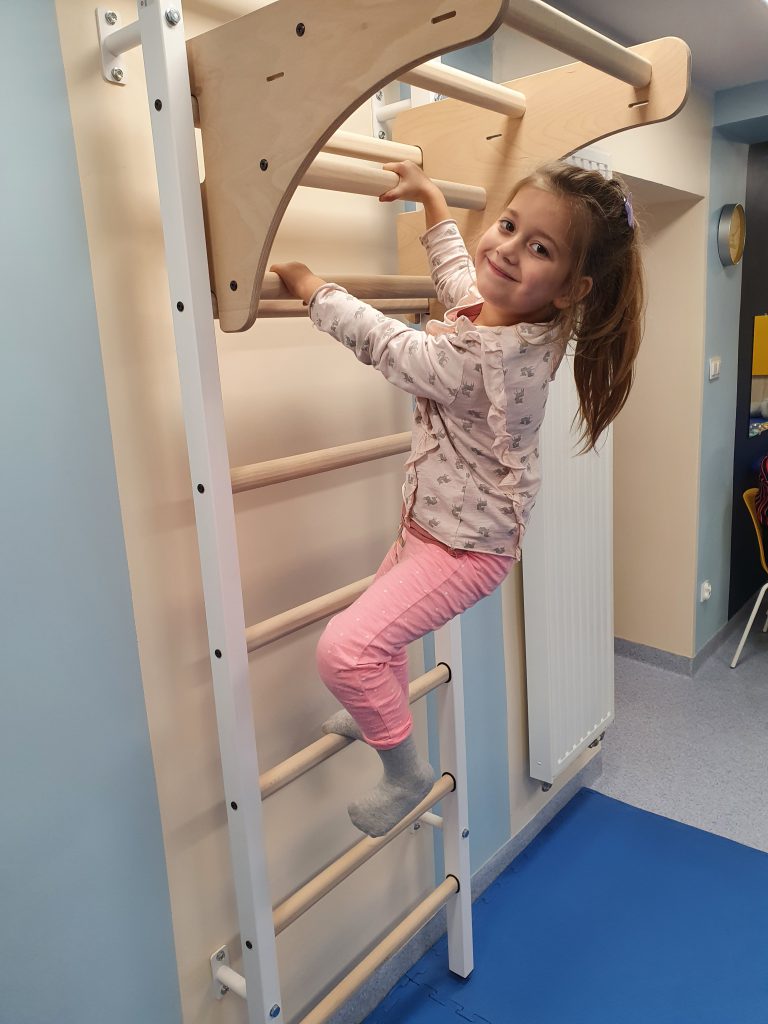 A child at a sports activity on a gymnastics ladder